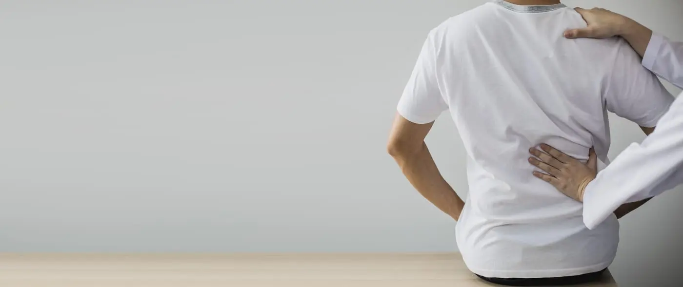 Chiropractor begeleidt een patiënt bij een oefening voor de onderrug